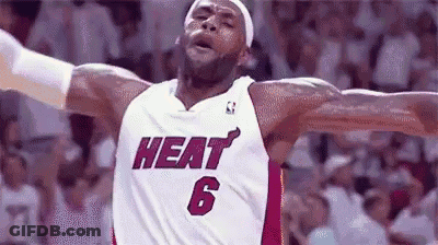 Lebron James Is Wearing A Heat Jersey With His Arms Outstretched During A Game . GIF