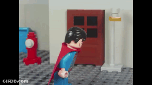 Lego Superman Standing In Front Of Red Door GIF