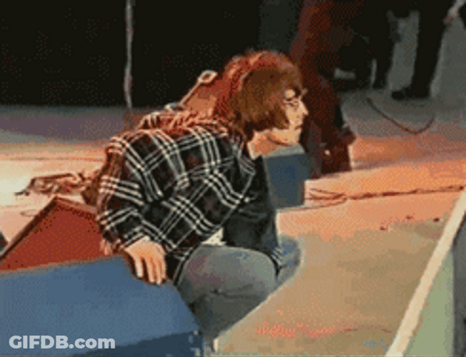 Liam Gallagher Squatting On Stage GIF
