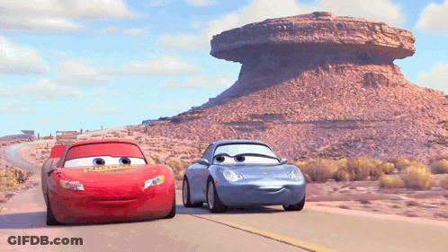 Lightning Mcqueen And Sally Are Driving Down A Desert Road GIF
