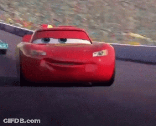 Lightning Mcqueen From Cars Is Driving Down A Race Track GIF
