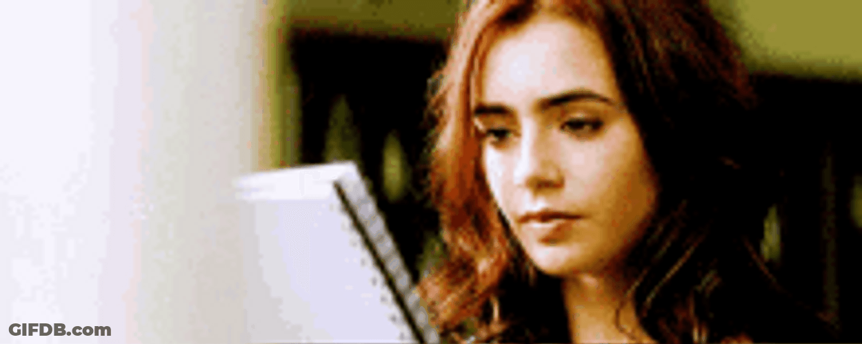 Lily Collins Looking Up From A Book GIF