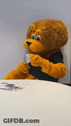 Lion Mascot Sitting At Table Holding Coffee Cup GIF