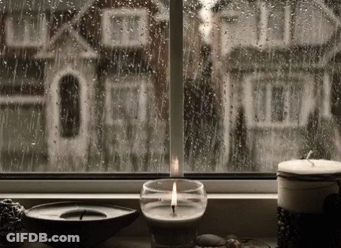 Lit Candle By Rainy Window With House GIF
