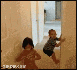 Little Boy And Little Girl Playing In Hallway GIF