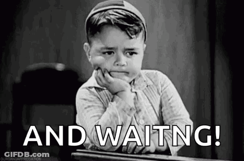 Little Boy At Desk With Hand On Chin Saying And Waiting GIF