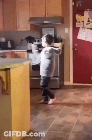 Little Boy Dancing In Kitchen With Farm Sign On Refrigerator GIF