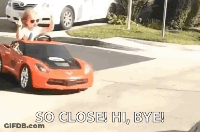Little Boy Driving Toy Car Down Street GIF