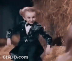 Little Boy In Tuxedo And Bow Tie Dancing In Dark Room GIF