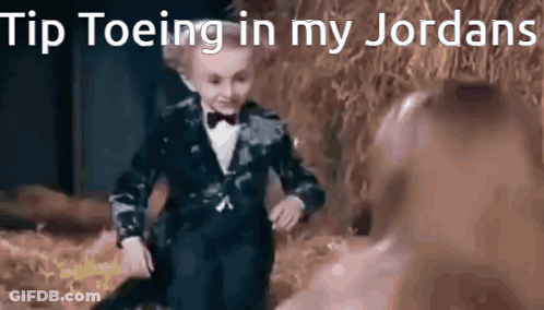 Little Boy In Tuxedo And Bow Tie Dancing In Field GIF