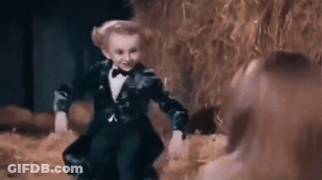 Little Boy In Tuxedo Dancing With Woman In Field GIF