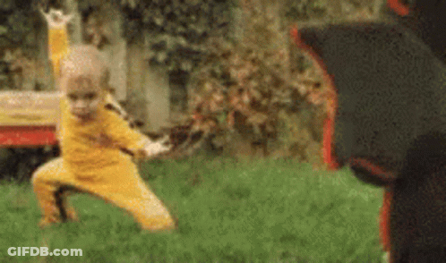 Little Boy In Yellow Practicing Martial Arts With Black Bear GIF