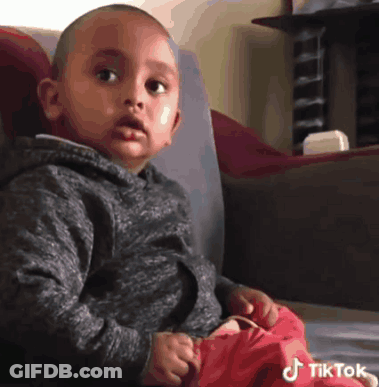 Little Boy On Couch Looking At Camera With TikTok Logo GIF