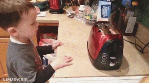 Little Boy Playing With Toaster Showing 6:00 GIF