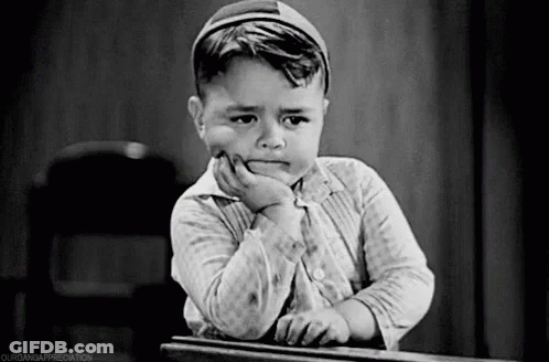 Little Boy Sitting At Desk With Hand On Chin Sad GIF