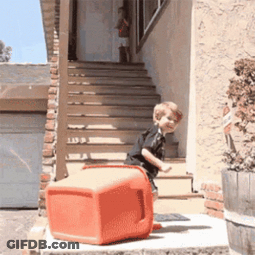 Little Boy Standing On Red Cooler On Porch GIF