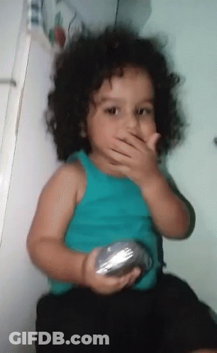 Little Curly Hair Girl Covering Mouth With Silver Object GIF