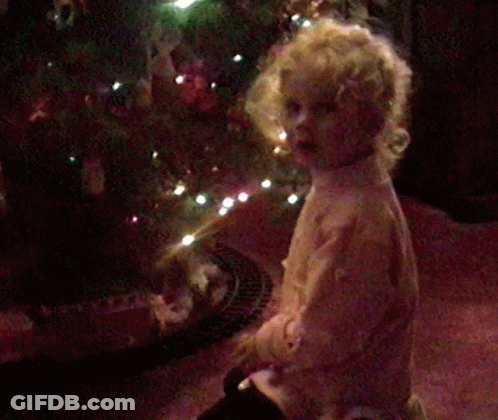 Little Girl Covering Face By Christmas Tree GIF