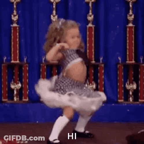 Little Girl Dancing On Stage In Front Of Blue Curtain GIF