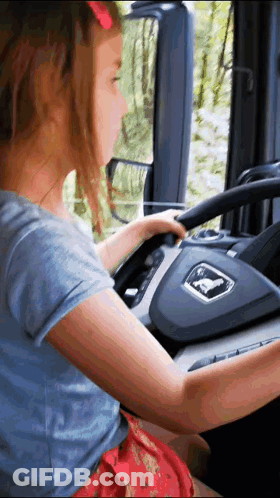 Little Girl Driving Truck With Man Logo GIF