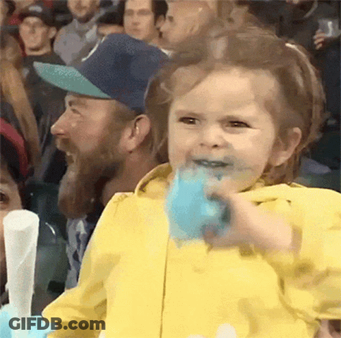 Little Girl Eating Cotton Candy In Crowd GIF