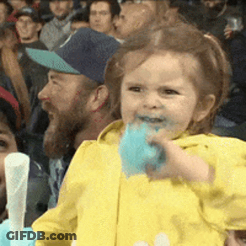Little Girl Eating Cotton Candy In Crowded Stadium GIF
