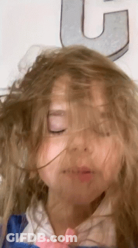 Little Girl Eyes Closed Hair Blowing In Wind In Front Of Letter U GIF