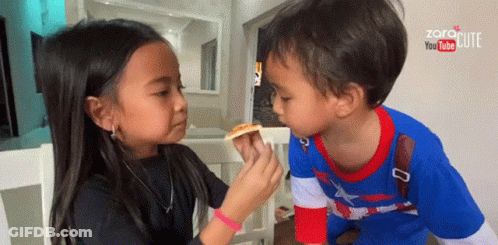 Little Girl Feeding Little Boy Slice Of Pizza GIF