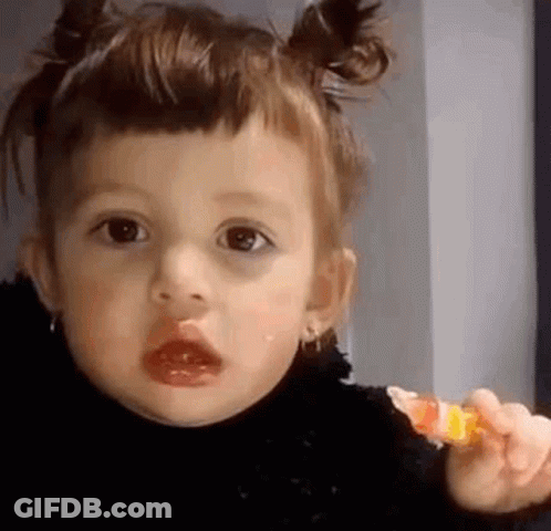 Little Girl Holding Lollipop Making Face GIF