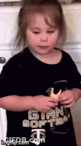 Little Girl In Black Shirt Holding Bread GIF