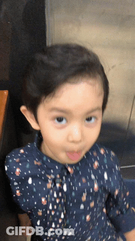 Little Girl In Blue Polka Dot Shirt Making Face GIF