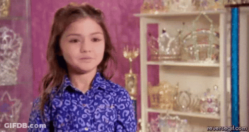 Little Girl In Blue Shirt At Tiara Display GIF