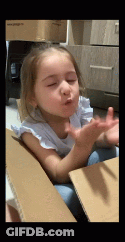 Little Girl In Cardboard Box Blowing A Kiss GIF