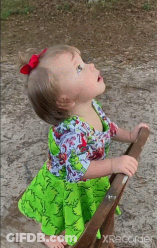 Little Girl In Green Dress Looking Up At Sky GIF