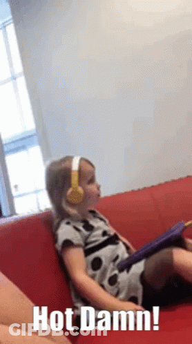 Little Girl In Headphones On Red Couch Saying Hot Damn GIF