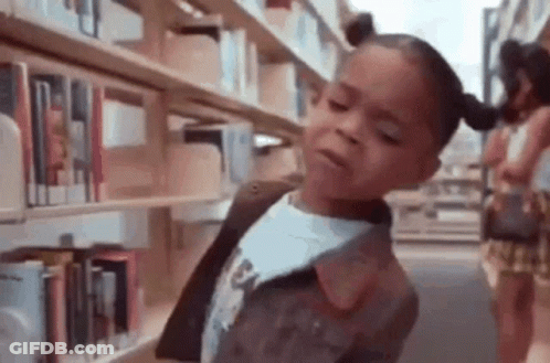 Little Girl In Library At Bookshelf GIF