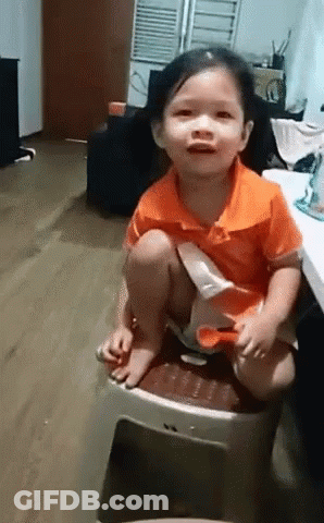 Little Girl In Orange Shirt Sitting On Stool GIF