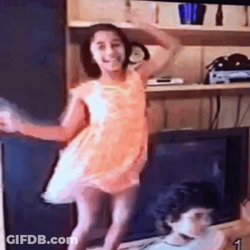 Little Girl In Pink Dress Dancing In Front Of TV GIF