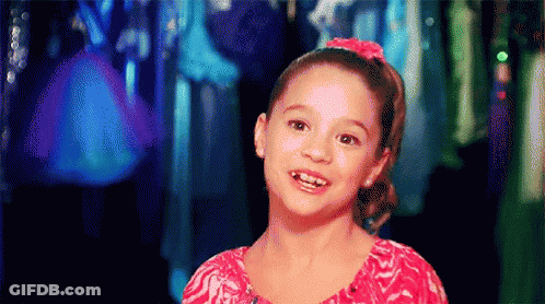 Little Girl In Pink Shirt Smiling In Front Of Closet GIF