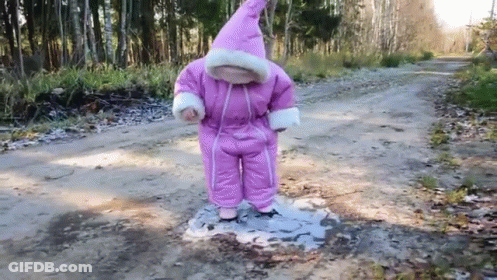 Little Girl In Pink Snow Suit Standing In Puddle GIF