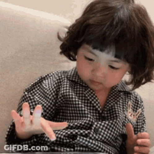 Little Girl In Plaid Shirt Playing With Tablet GIF