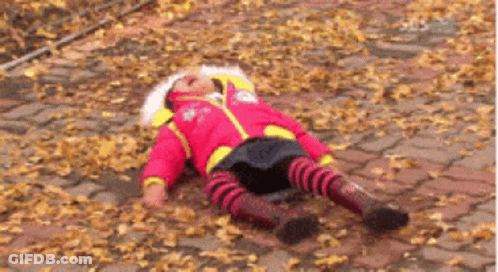 Little Girl In Red Jacket Laying On Ground GIF