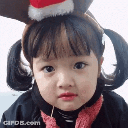 Little Girl In Reindeer Headband And Christmas Hat GIF