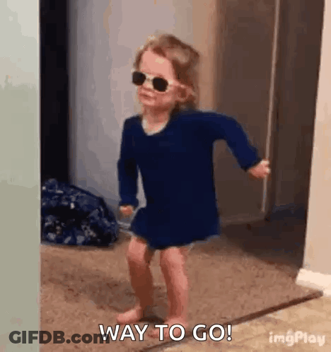 Little Girl In Sunglasses And Blue Dress Dancing In Hallway GIF