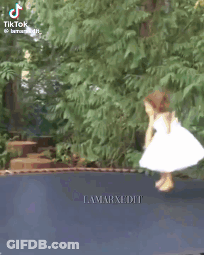 Little Girl In White Dress Jumping On Trampoline GIF