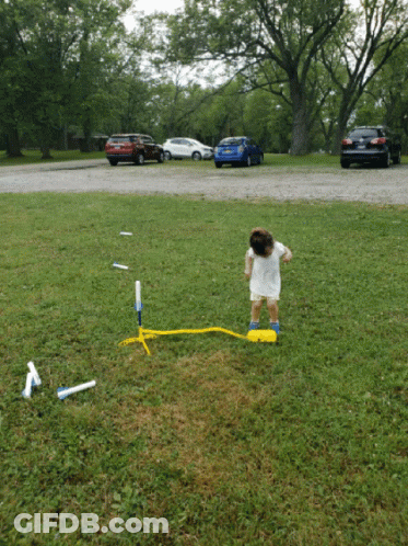 Little Girl In White Dress Playing With Rocket GIF