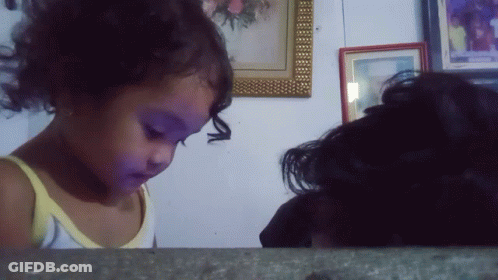 Little Girl In Yellow Tank Top Looking At Picture GIF
