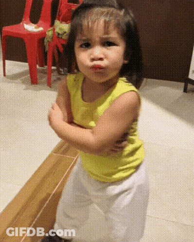 Little Girl In Yellow Tank Top Making A Face GIF