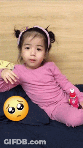 Little Girl Laying On Bed With Sad Face GIF