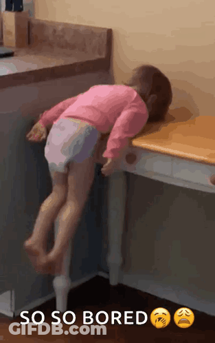 Little Girl Laying On Table Saying So So Bored GIF